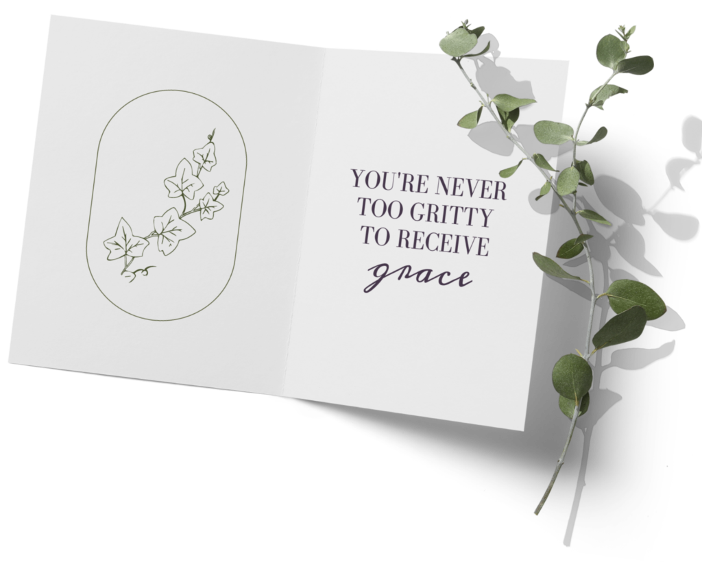Greeting card lying open next to a eucalyptus brand that says "You are never too gritty to recieve grace"